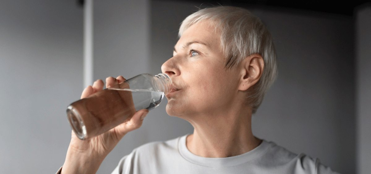 Seniorin trinkt Wasser